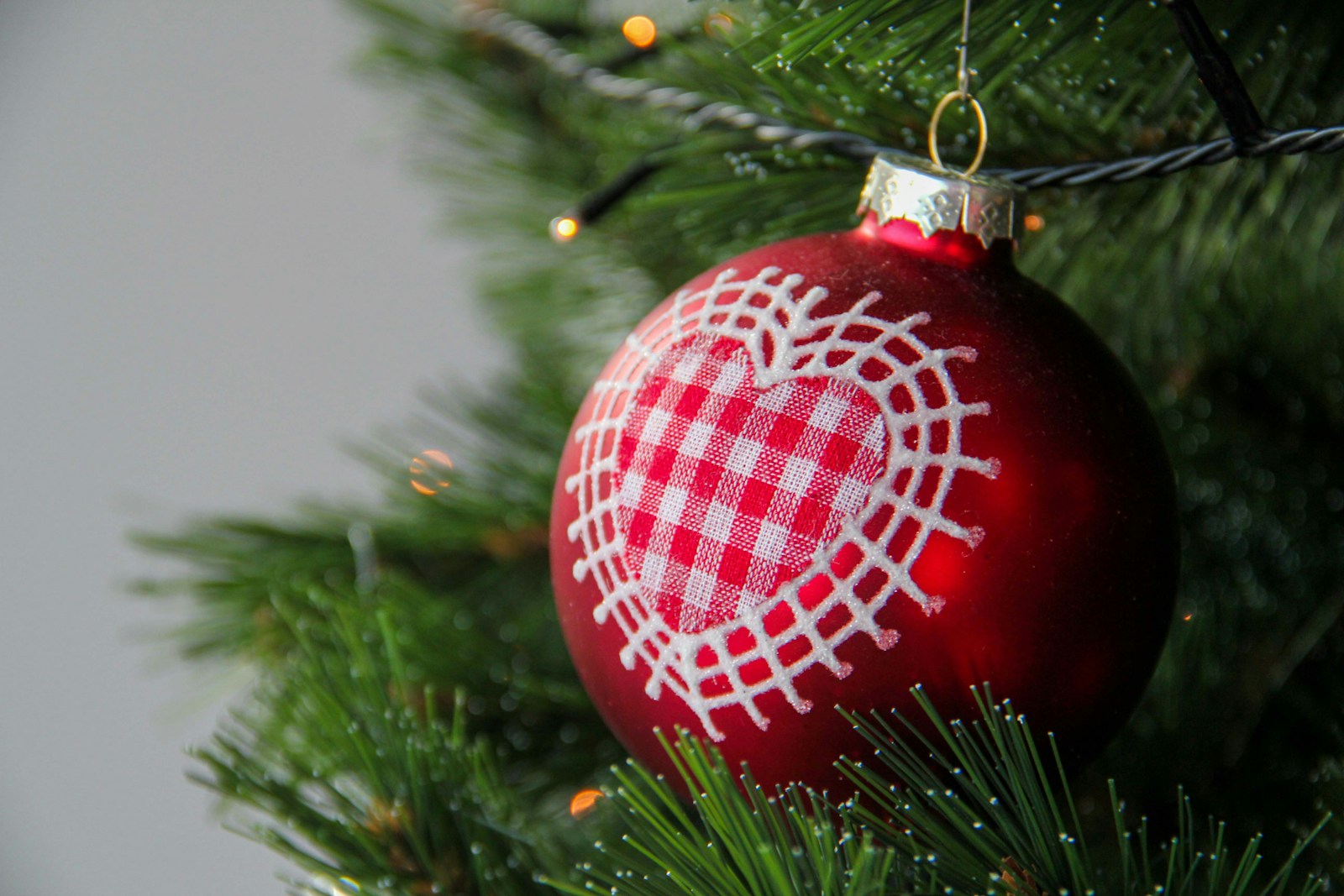 a red ornament hanging from a christmas tree