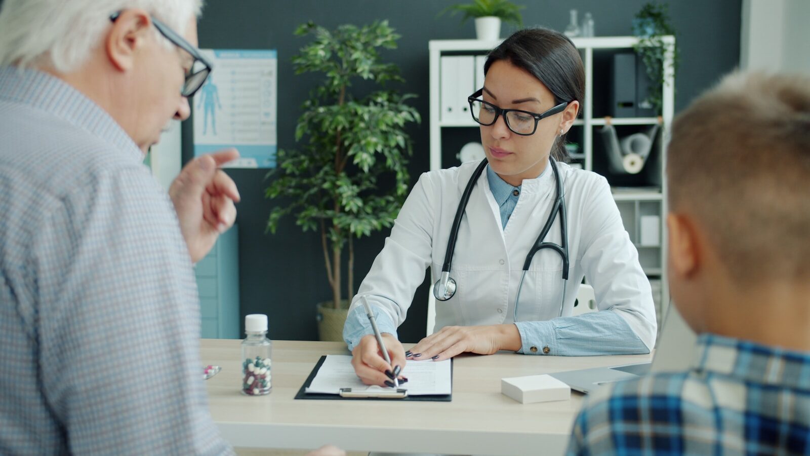 Doctor consults with elderly man and child.